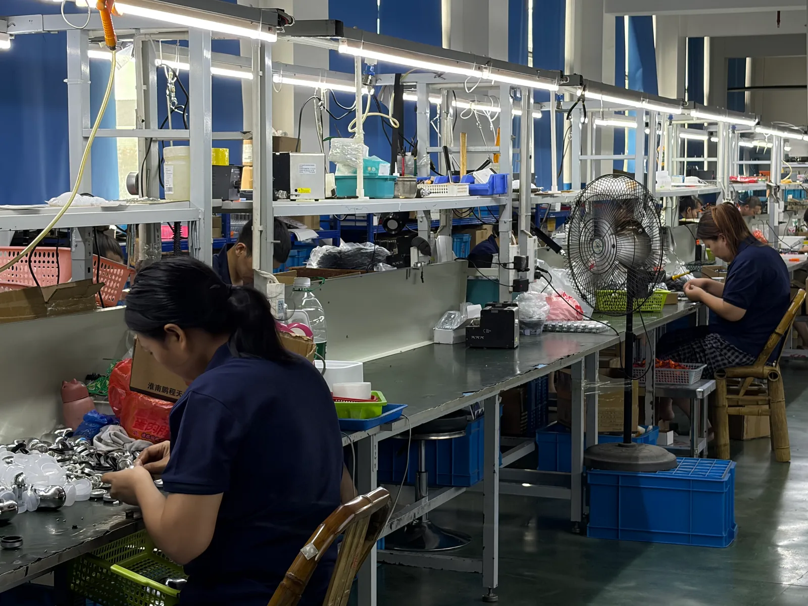 Appliance assembly line with operators at illuminated workstations